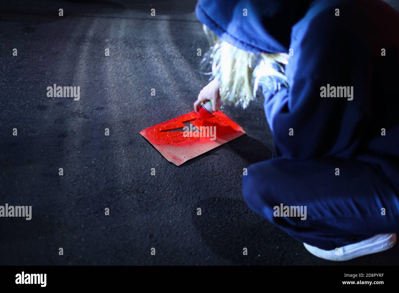 Cracovia, Polonia. 28 Ott 2020. Un protestore dipinge sulla strada il simbolo dello sciopero femminile, fulmine rosso, utilizzando una vernice spray e un modello di cartone durante la dimostrazione.la Corte costituzionale polacca nella sua nuova, il tribunale scelto politicamente ha stabilito che l'aborto è incostituzionale nei casi in cui vi è un'alta probabilità di danni gravi e irreversibili al feto o di una malattia incurabile che minaccia la sua vita. Nel caso della Polonia, ciò significa un divieto quasi totale dell'aborto. A seguito della decisione della corte sono iniziate grandi proteste in tutte le principali città polacche. Per a. Foto Stock