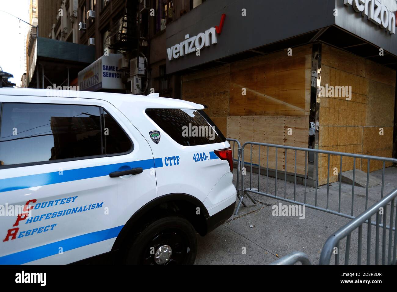 Una macchina di polizia è parcheggiata di fronte ad un imbarco su Verizon store.The New York City Police Department ha emesso un avvertimento per i commercianti situati in molte aree della città per prepararsi come il giorno delle elezioni si avvicina. Alcune parti della città che sono state colpite dal saccheggio dopo l'uccisione della polizia di George Floyd sono particolarmente vulnerabili. Foto Stock