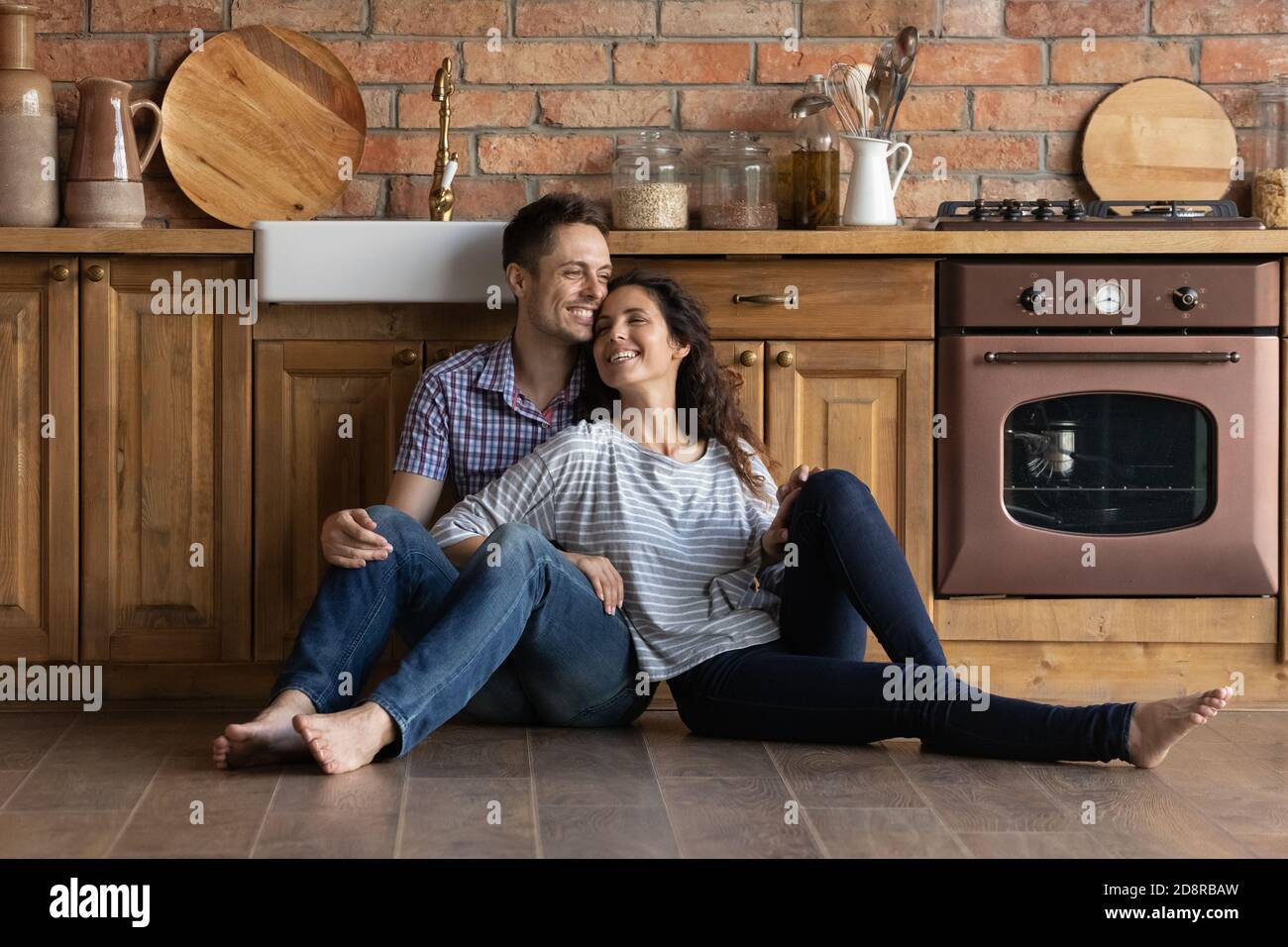 Una coppia sorridente si rilassa nell'accogliente cucina casalinga Foto Stock
