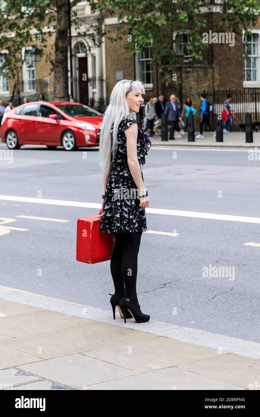 L'assistente ministeriale femminile tiene la scatola rossa del governo britannico, la scatola ministeriale (scatola di spedizione) fuori dall'ufficio del gabinetto, Whitehall, Westminster, Londra, Regno Unito Foto Stock