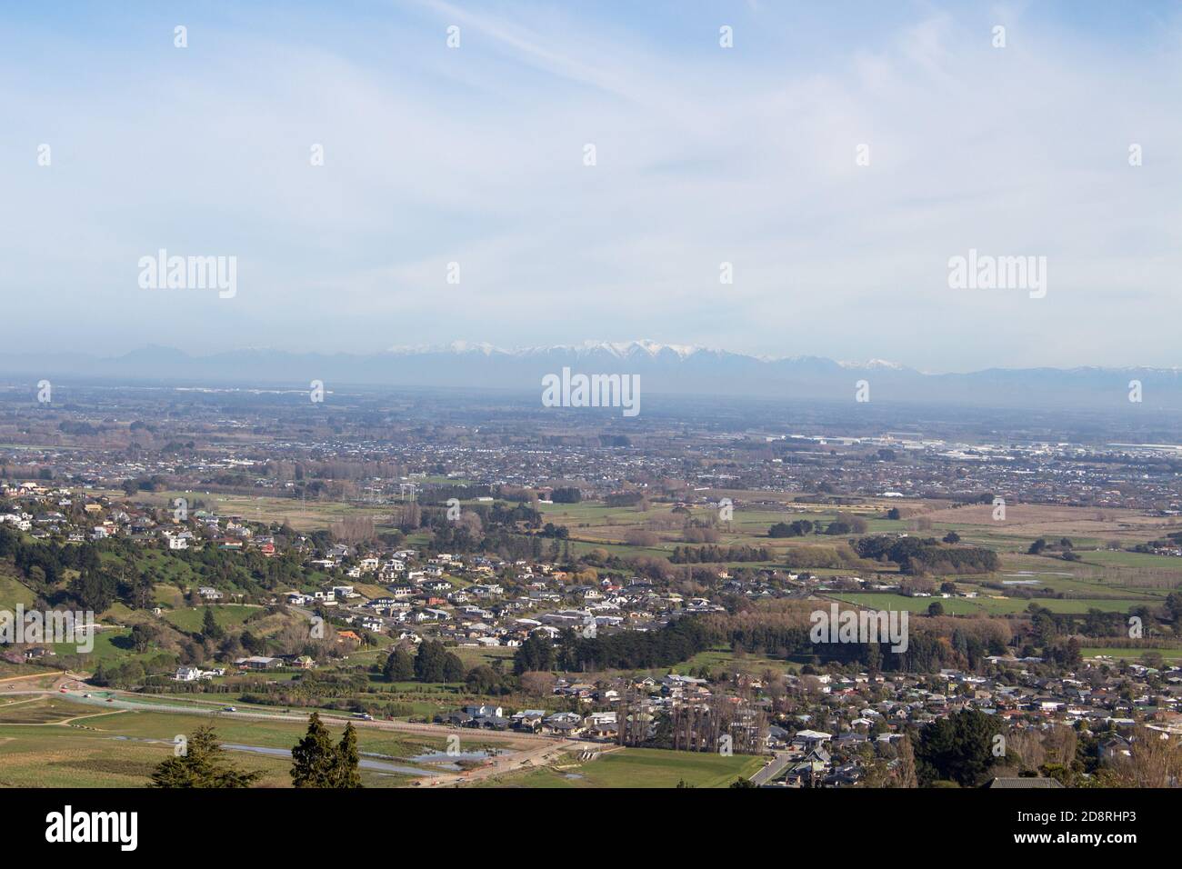 Si affaccia sulla città di Christchurch da una collina che guarda attraverso gli alberi e le montagne dallo sfondo Foto Stock