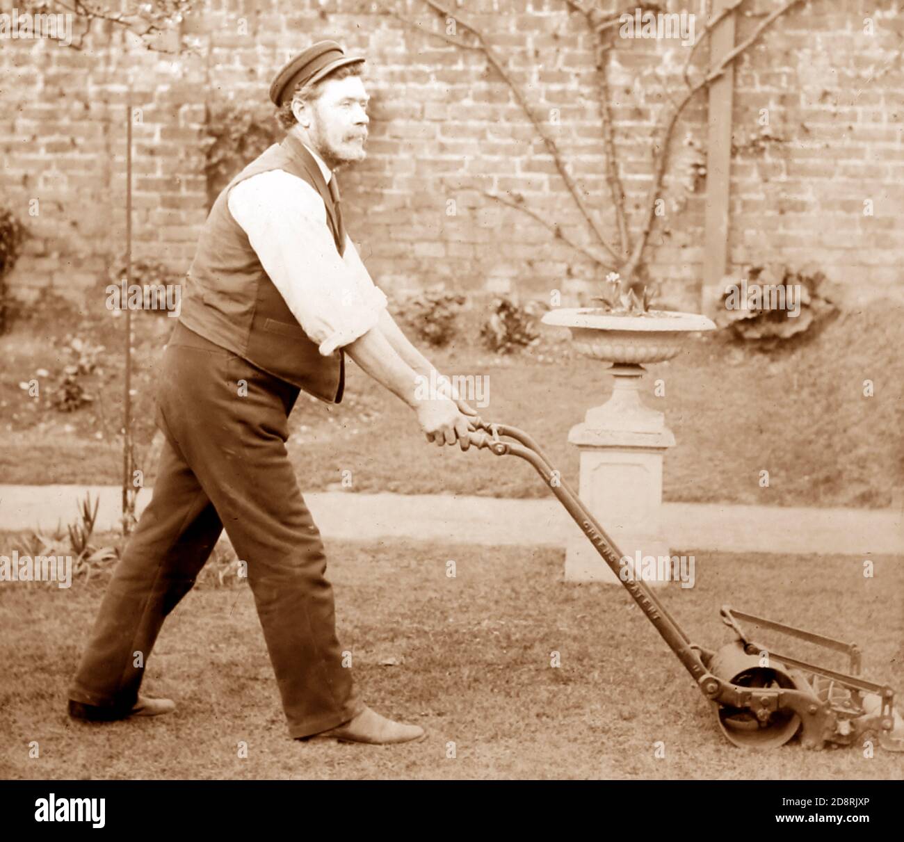Giardiniere che falciava un prato con un tosaerba Thomas Green, periodo vittoriano Foto Stock