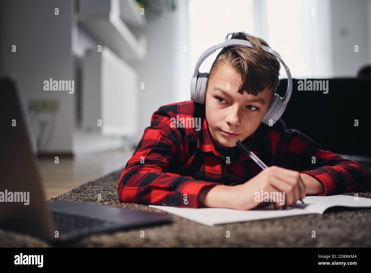 Lezione di scuola online. Teenager che impara via Internet con il laptop a casa. Foto Stock