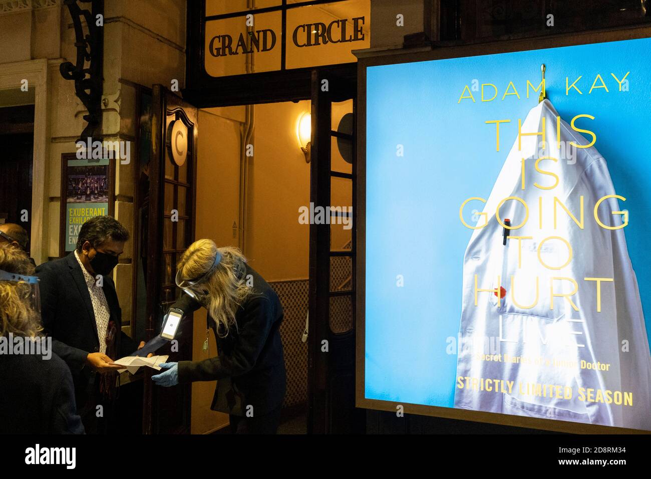 Mentre il primo ministro Boris Johnson annuncia un secondo blocco a livello nazionale di Coronavirus durante la seconda ondata della pandemia, il personale controlla i biglietti dei clienti fuori dall'Apollo Theatre su Shaftesbury Avenue, dove la commedia medica di Adam Kay "This is going to Hurt" sta suonando, il 31 ottobre 2020, a Londra, in Inghilterra. Ma gli affari come i teatri dovranno ancora chiudere da Giovedi, e per un periodo di almeno un mese. Foto Stock
