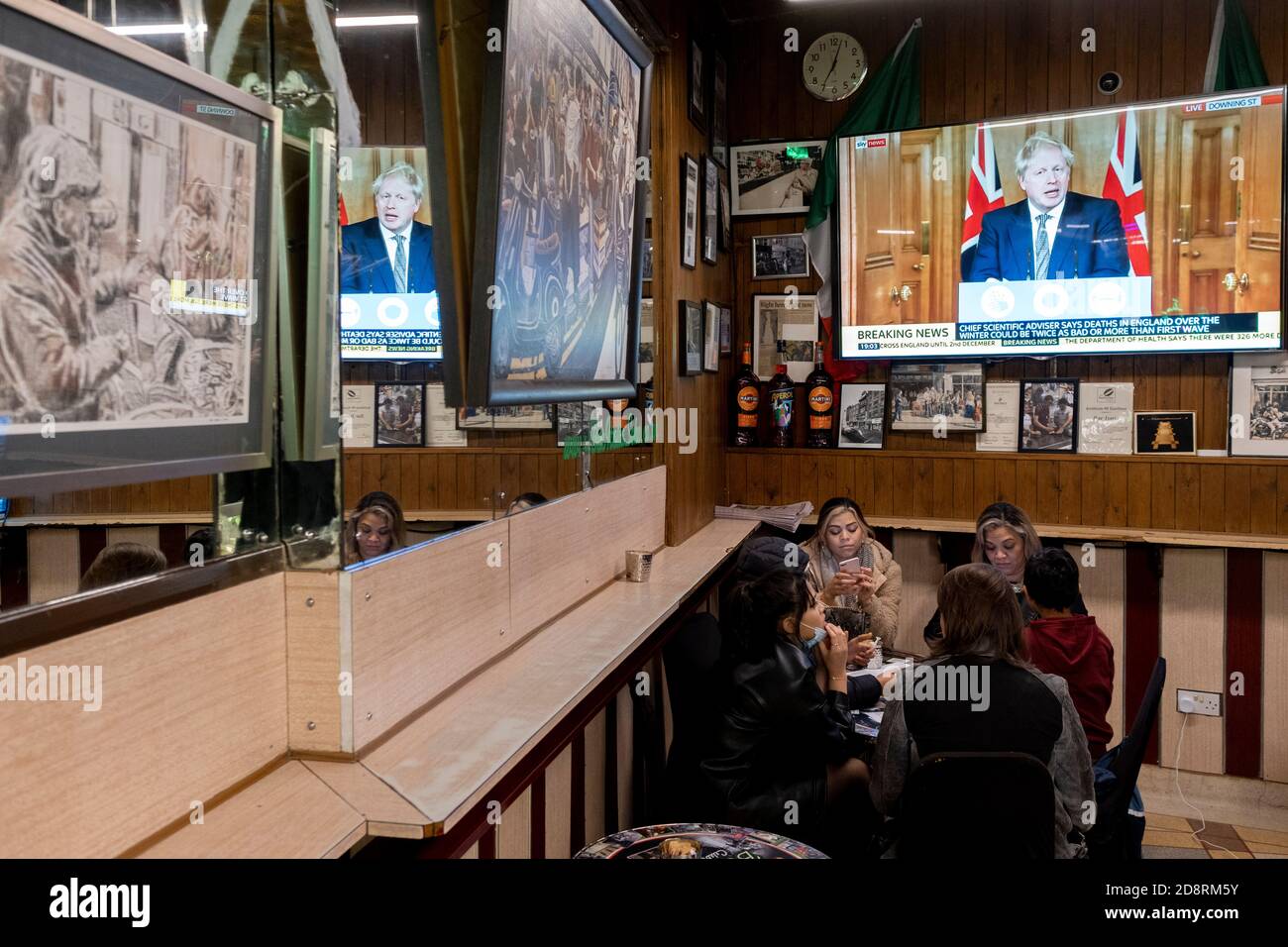 Su uno schermo televisivo di Bar Italia, il famoso caffè italiano di Soho, il primo ministro Boris Johnson si rivolge al Regno Unito in diretta TV per annunciare un secondo blocco nazionale durante la seconda ondata della pandemia di Coronavirus, il 31 ottobre 2020, a Londra, Inghilterra. Le aziende come Bar Italia dovranno chiudere di nuovo, tranne che per le asporto, a partire dalla mezzanotte del giovedì per un periodo di un mese. Foto Stock