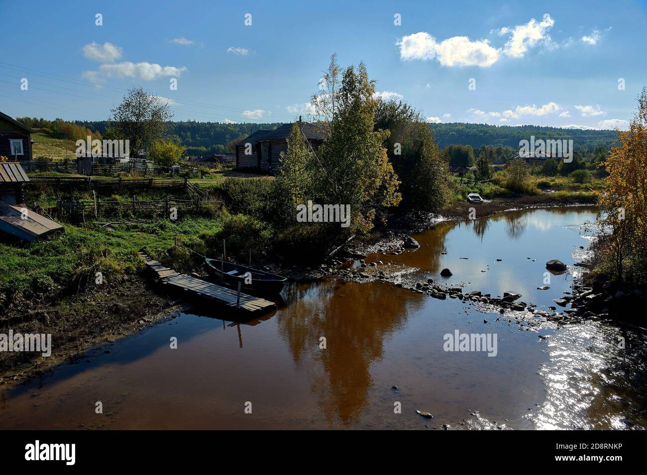 Fiume poco profondo sullo sfondo del villaggio Foto Stock