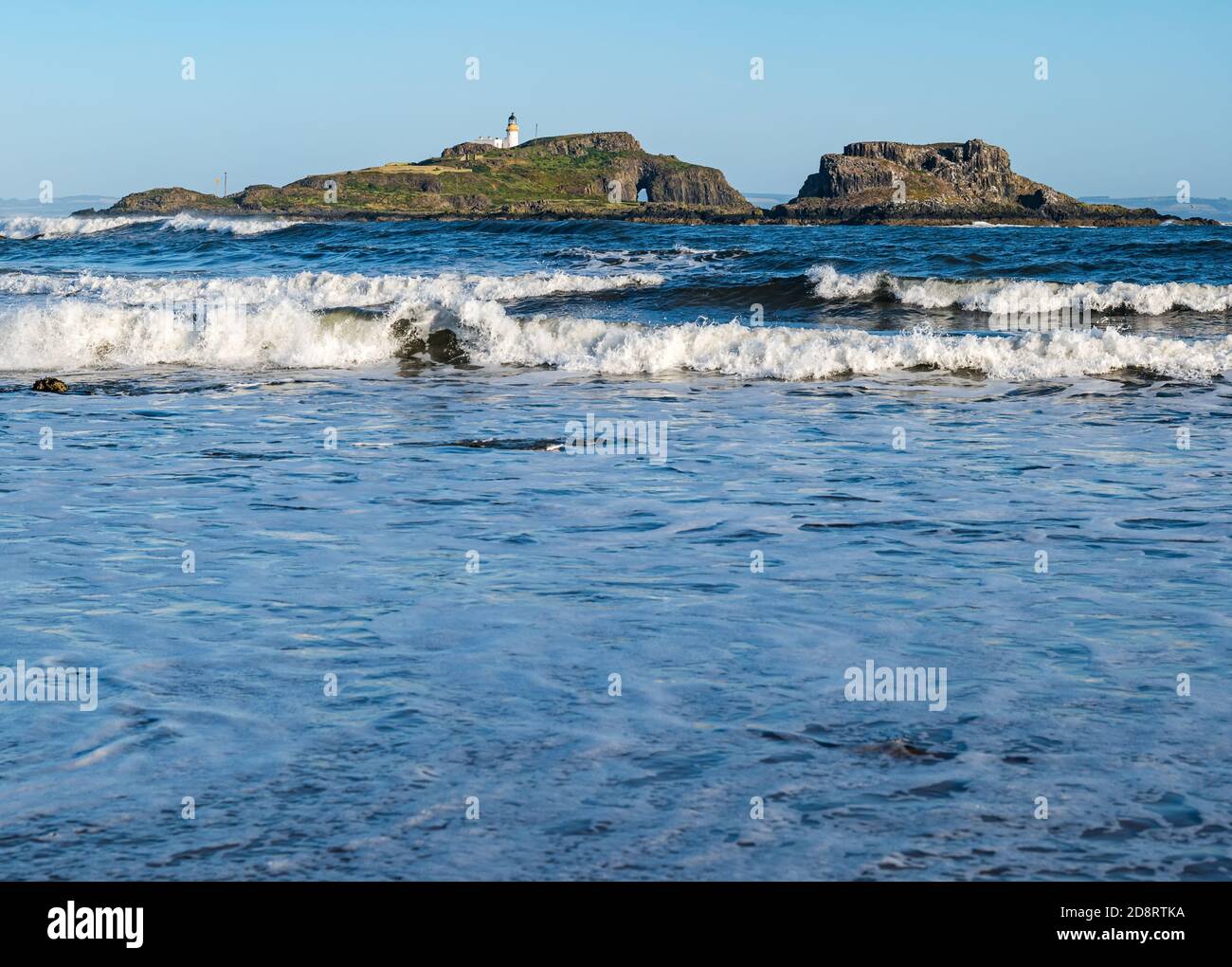Isola di Fidra e faro in giornata di sole con le onde, Yellowcraig spiaggia, East Lothian, Scozia, Regno Unito Foto Stock