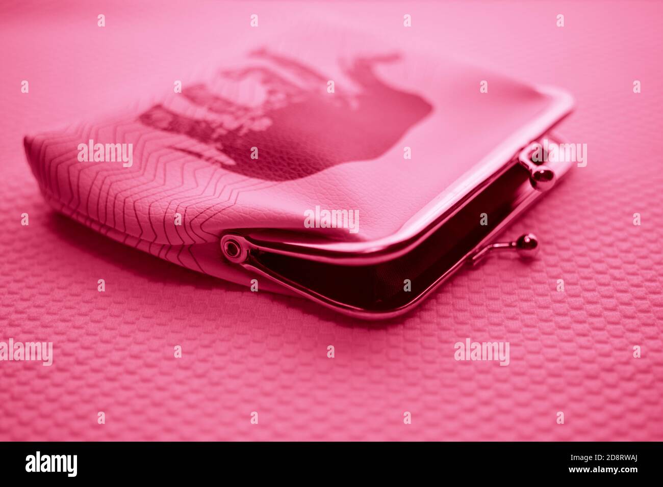 Aprire il portamonete per le monete. Portafoglio per il cambio. Portamonete in pelle su un tavolo. Luce rosa. Foto Stock