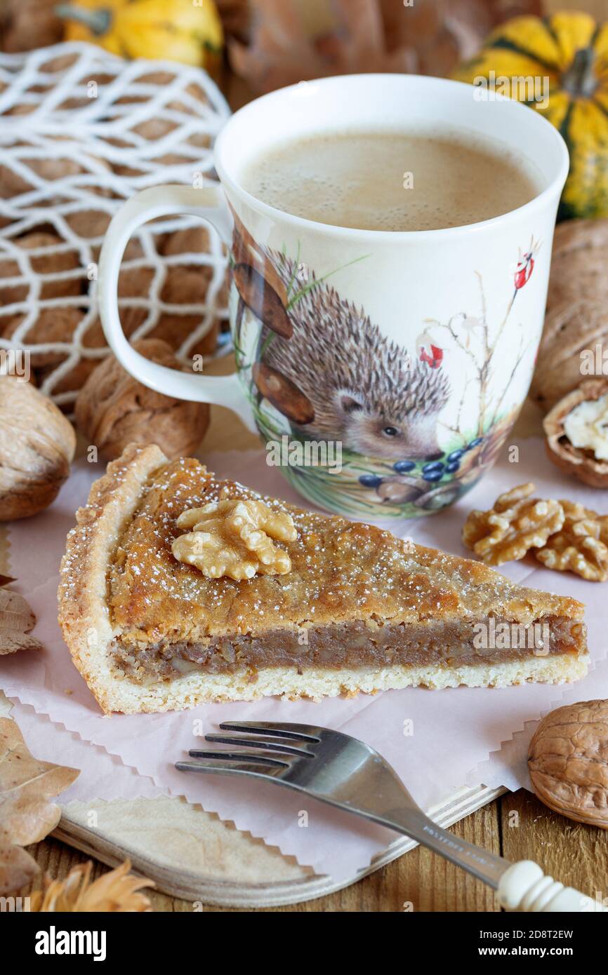 pezzo di crostata di noce e tazza di caffè su legno scheda Foto Stock