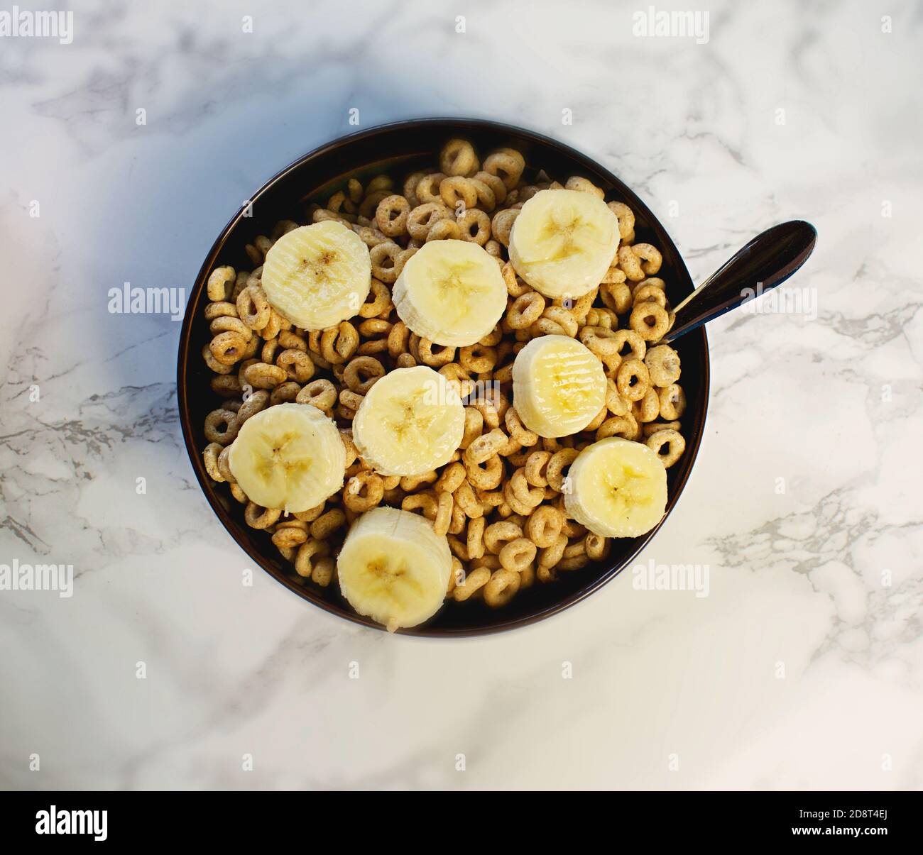 Guardando verso il basso la ciotola di cereali con le fette di banana Foto Stock