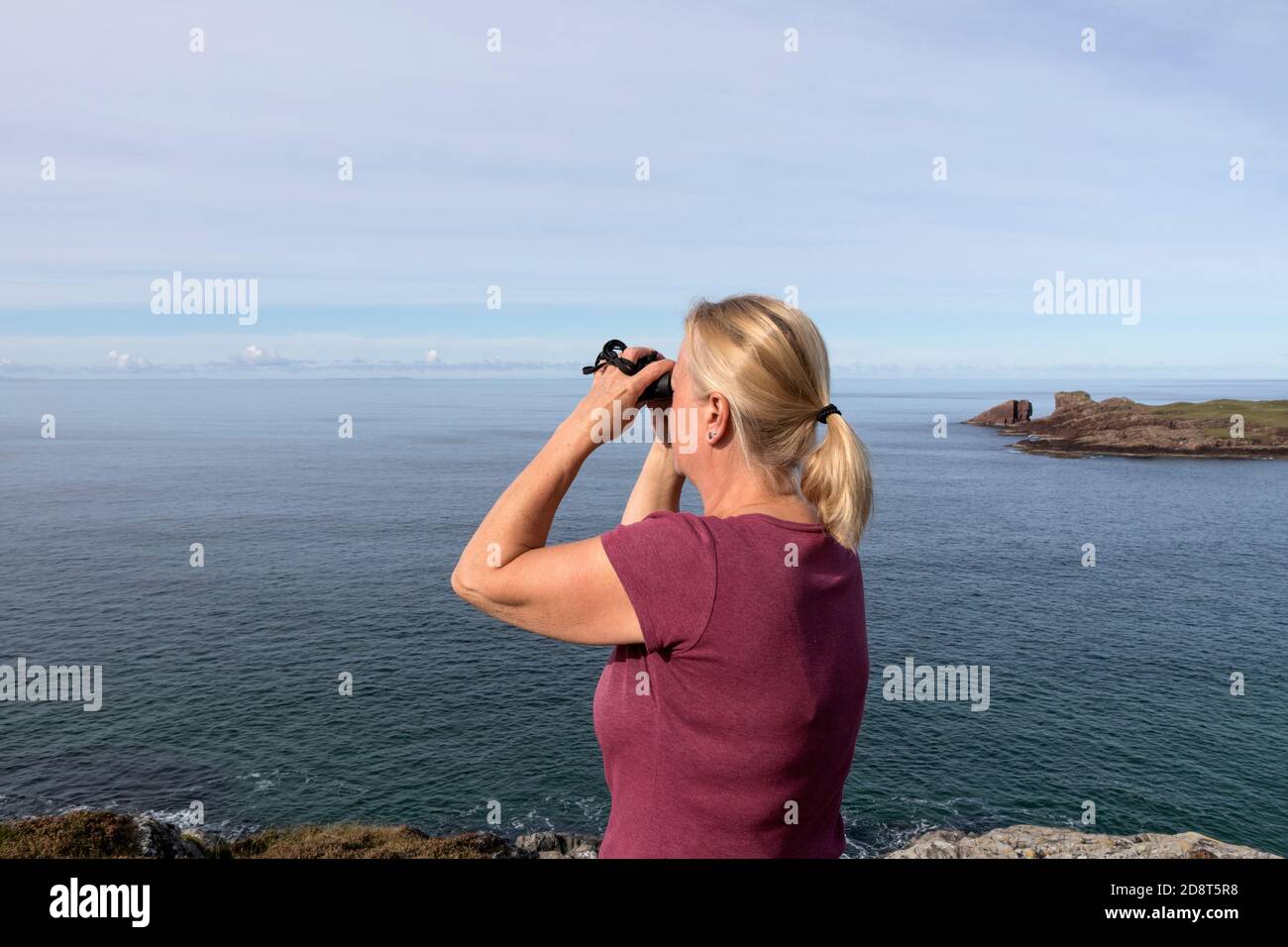 Woman Wildlife watching vicino a Split Rock, Clachtold, Assynt, NW Highlands, Scozia, Regno Unito Foto Stock