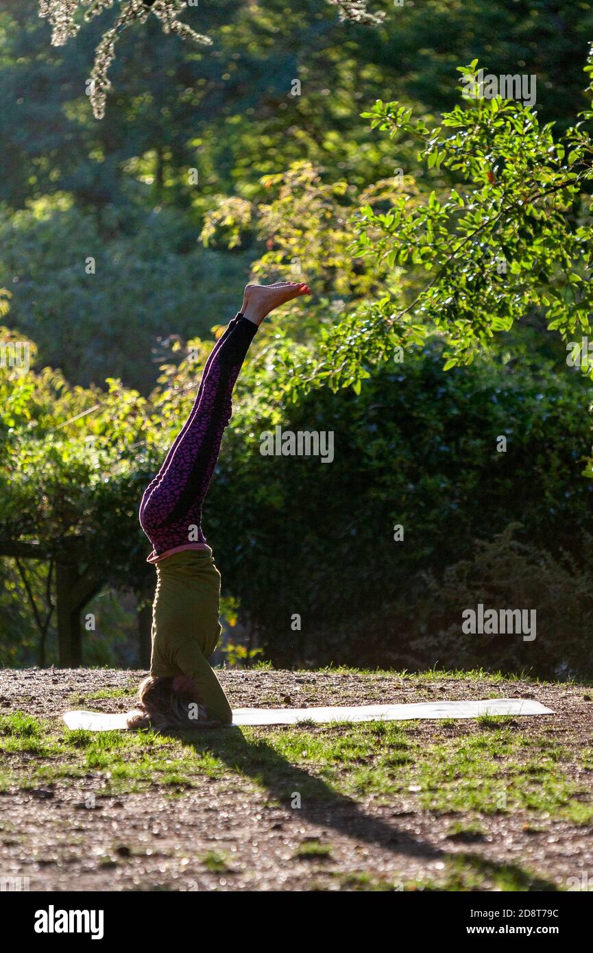 Donna bionda, quaranta anni pratica yoga pone in un ambiente esterno, Londra, Inghilterra Foto Stock