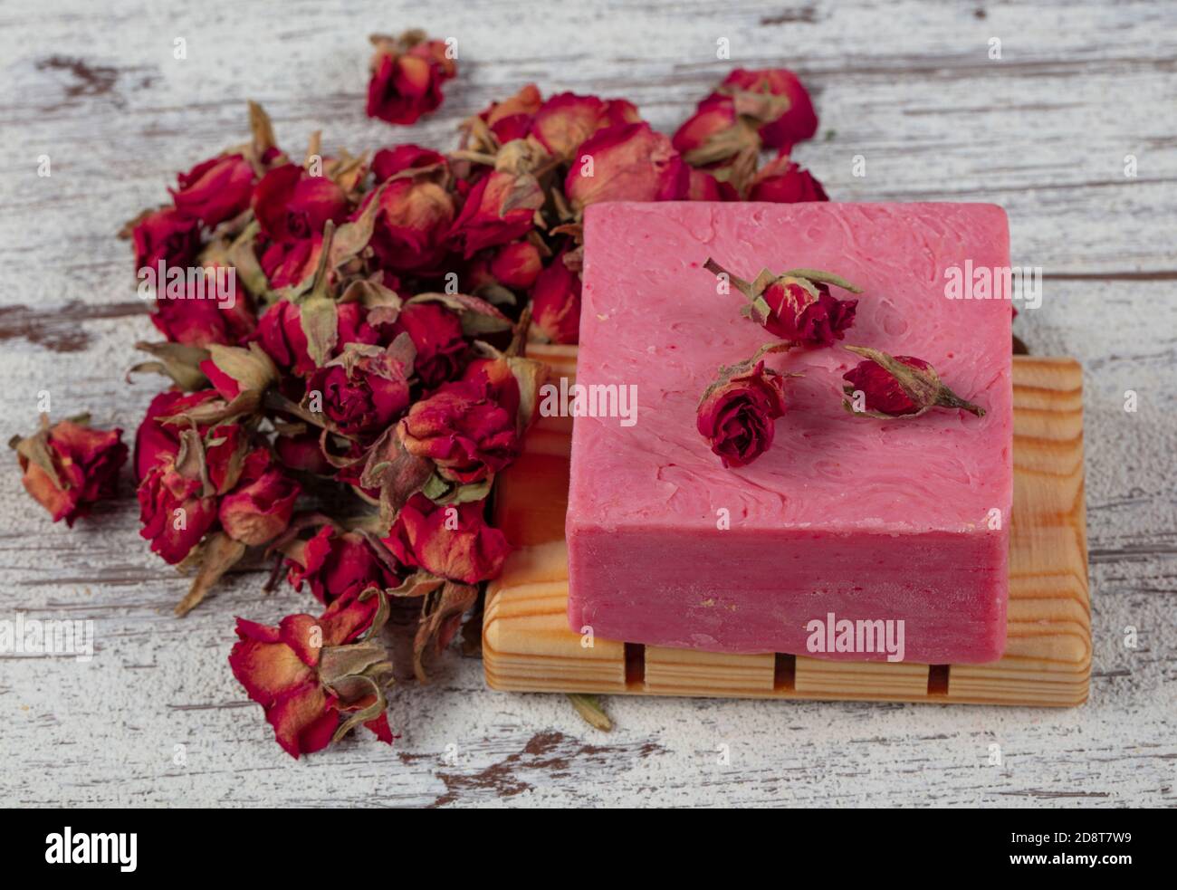 Sapone naturale, sapone rosa. Sapone naturale fatto a mano con rose rosa appassite su tavola di legno. Centro benessere Foto Stock