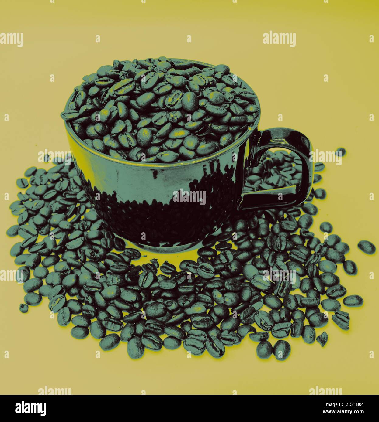 Tazza o tazza piena di chicchi di caffè interi, che traboccano la tazza. Con chicchi di caffè interi che circondano la tazza. Con il verde sfumato e un filtro giallo. Foto Stock