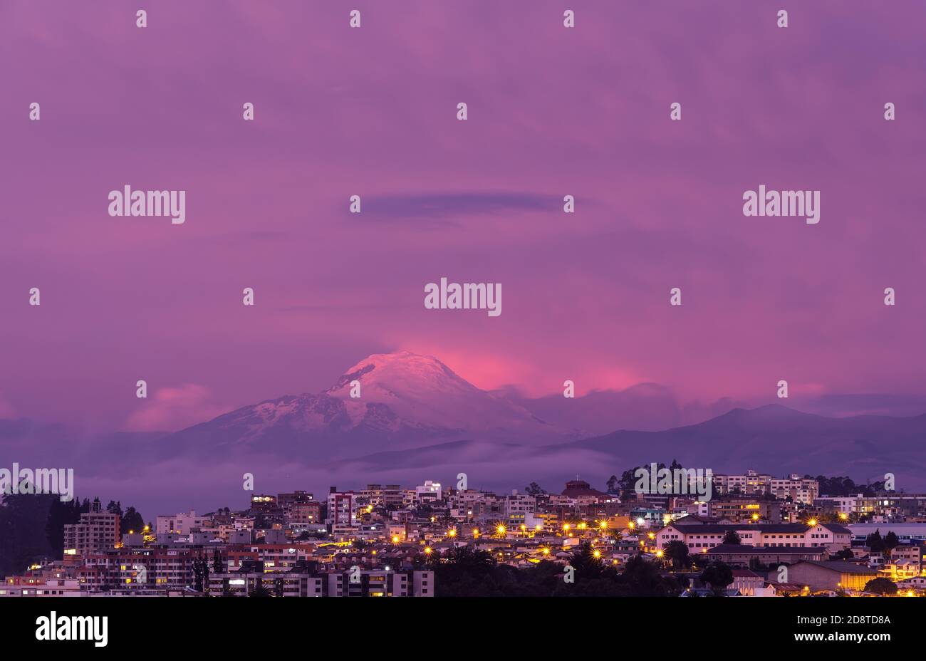 Vulcano Cayambe al tramonto con il paesaggio urbano aereo della città di Quito, Ecuador. Foto Stock