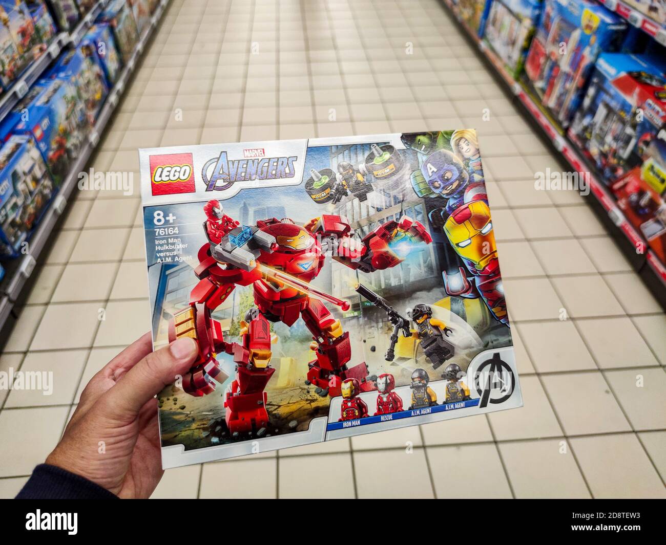 Puilboreau, Francia - 14 ottobre 2020: Primo piano di uomo mano che acquista Avenger Marvel figurine Lego marca display per la vendita nel supermercato francese Foto Stock