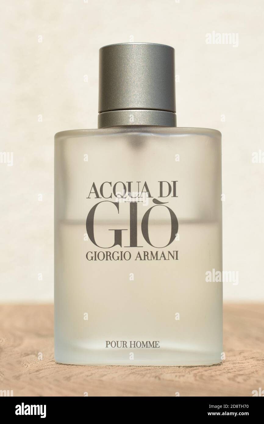 Primo piano di una bottiglia Giorgio Armani acqua di Gio pour homme, eau de toilette. Su un tavolo di legno con sfondo luminoso Foto Stock