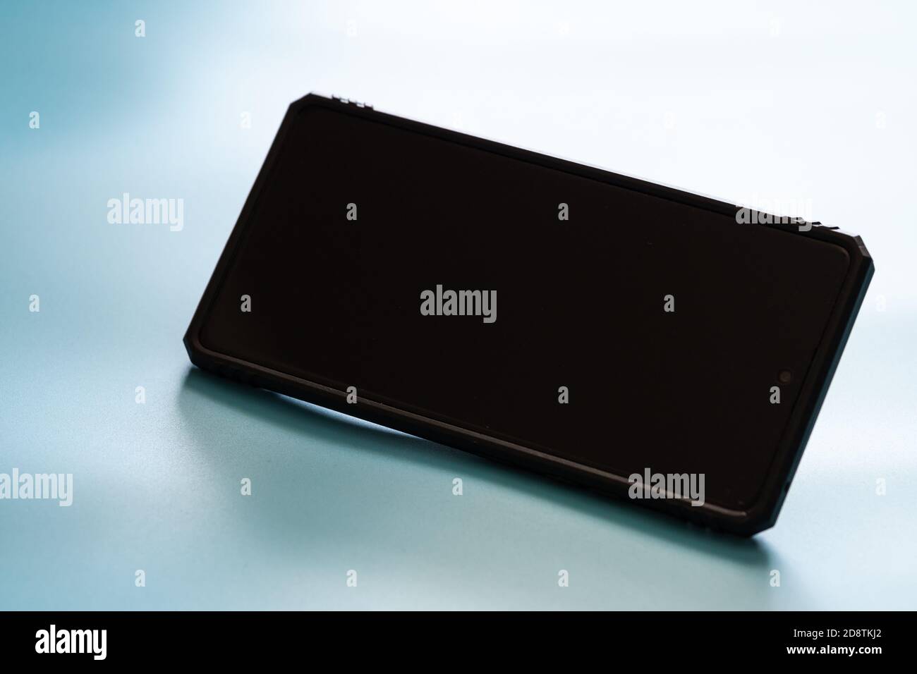 Smartphone con schermo nero e custodia e spazio per la copia colore sfondo blu stile di tonalità e umore Foto Stock