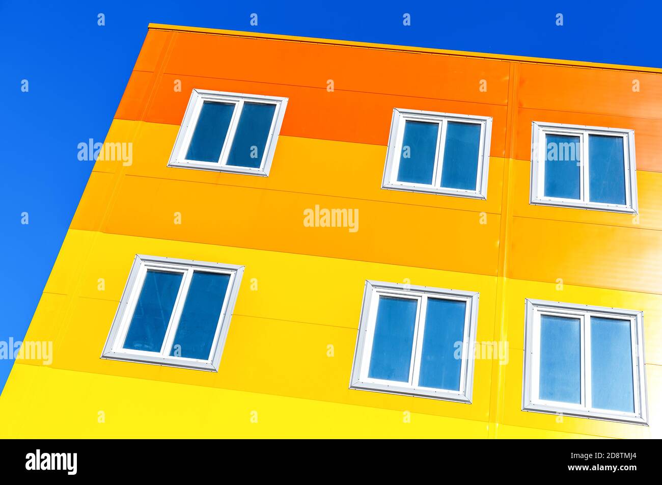 Nuovo edificio di appartamenti luminoso e colorato su sfondo blu del cielo Foto Stock