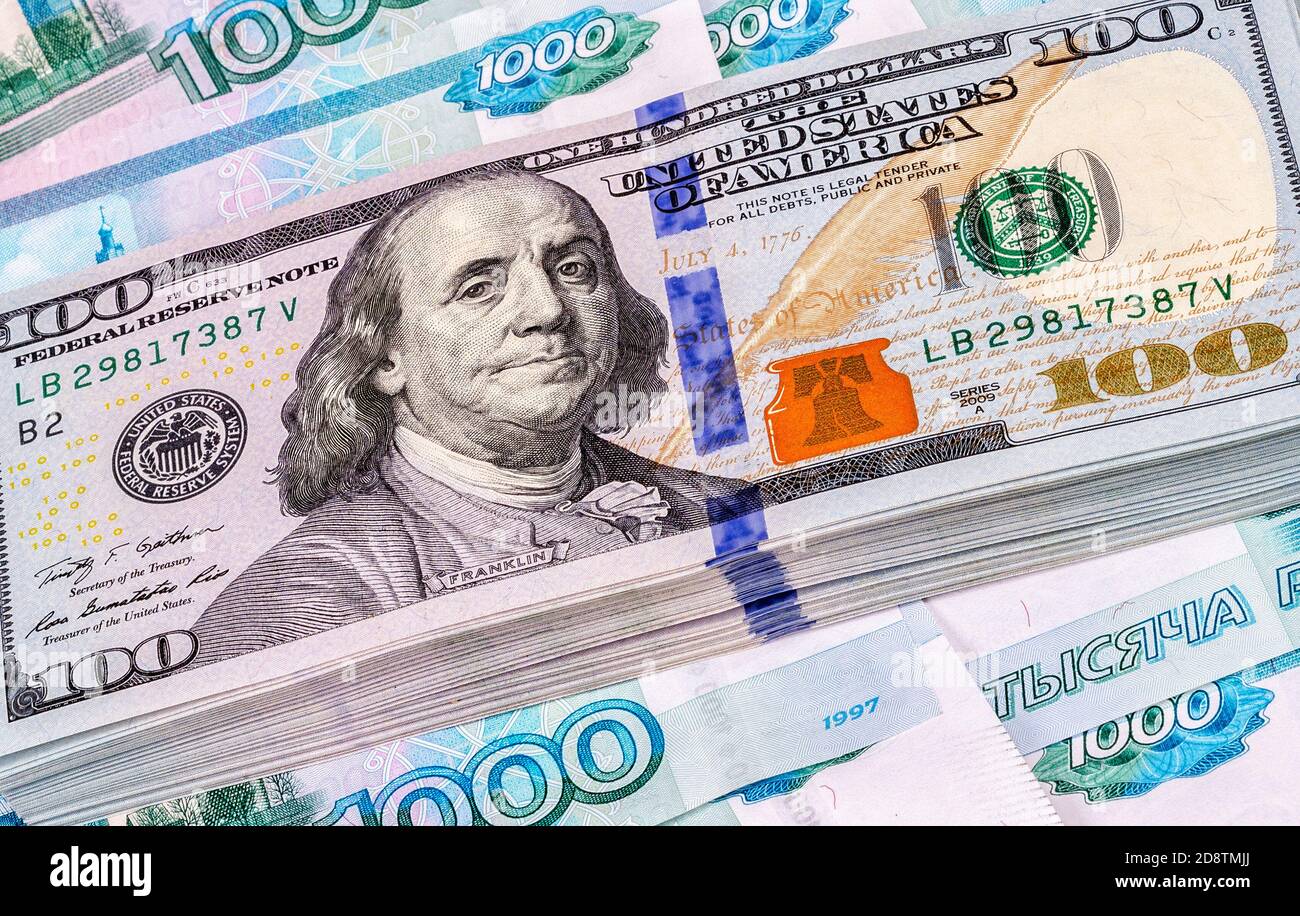 Un mucchio di cento banconote in dollari americani sulle rubli russi, primo piano Foto Stock