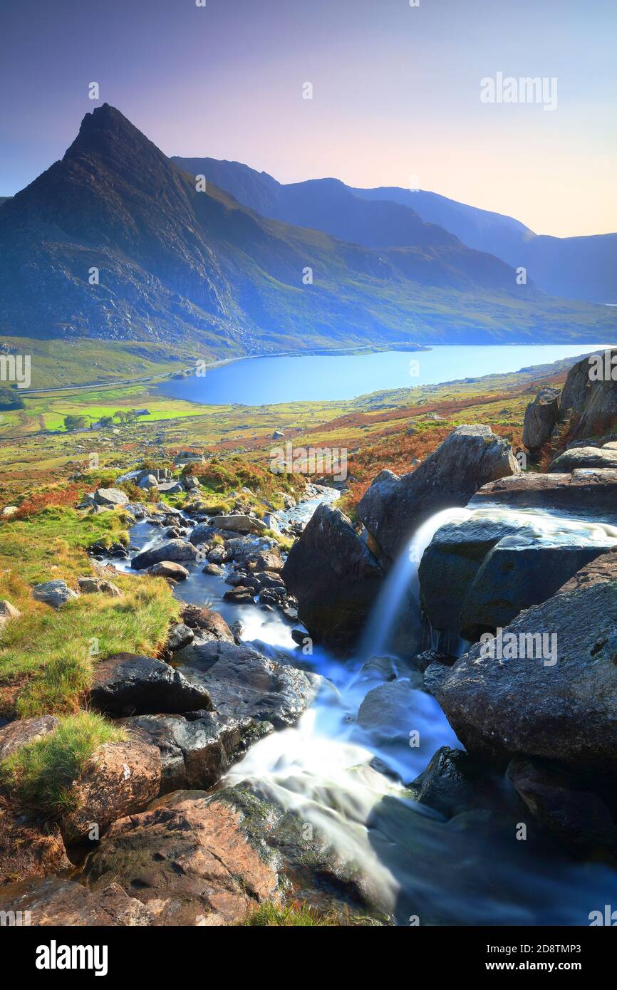 Piccola cascata con Tryfan e Lyl Ogwen sullo sfondo in un giorno di sole, Snowdonia National Park, Galles del Nord, Regno Unito. Foto Stock