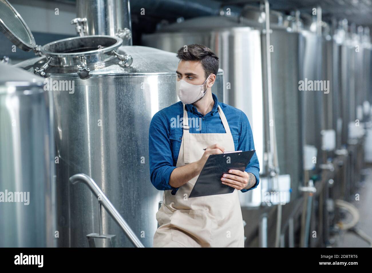 Il lavoratore controlla i dati sulla linea di produzione in fabbrica Foto Stock