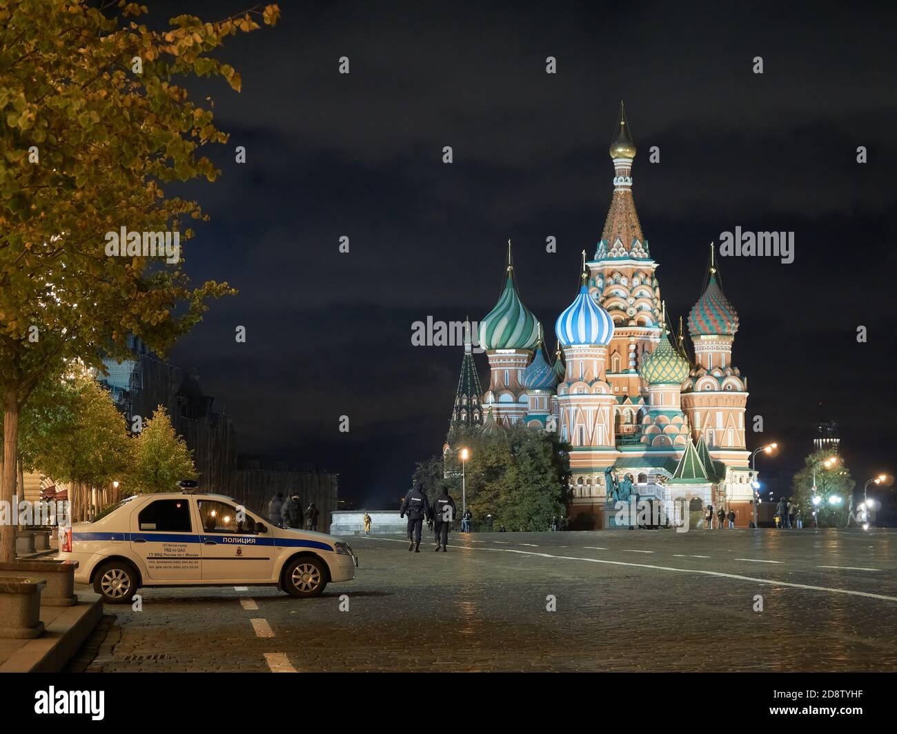 Una macchina di polizia è vista in servizio proprio sulla piazza di fronte alla Cattedrale di San Basilio. A tarda sera a Mosca, nel cuore della Russia - in Piazza Rossa, le persone, come le ombre, passano per la notte secolare storia del paese. Foto Stock