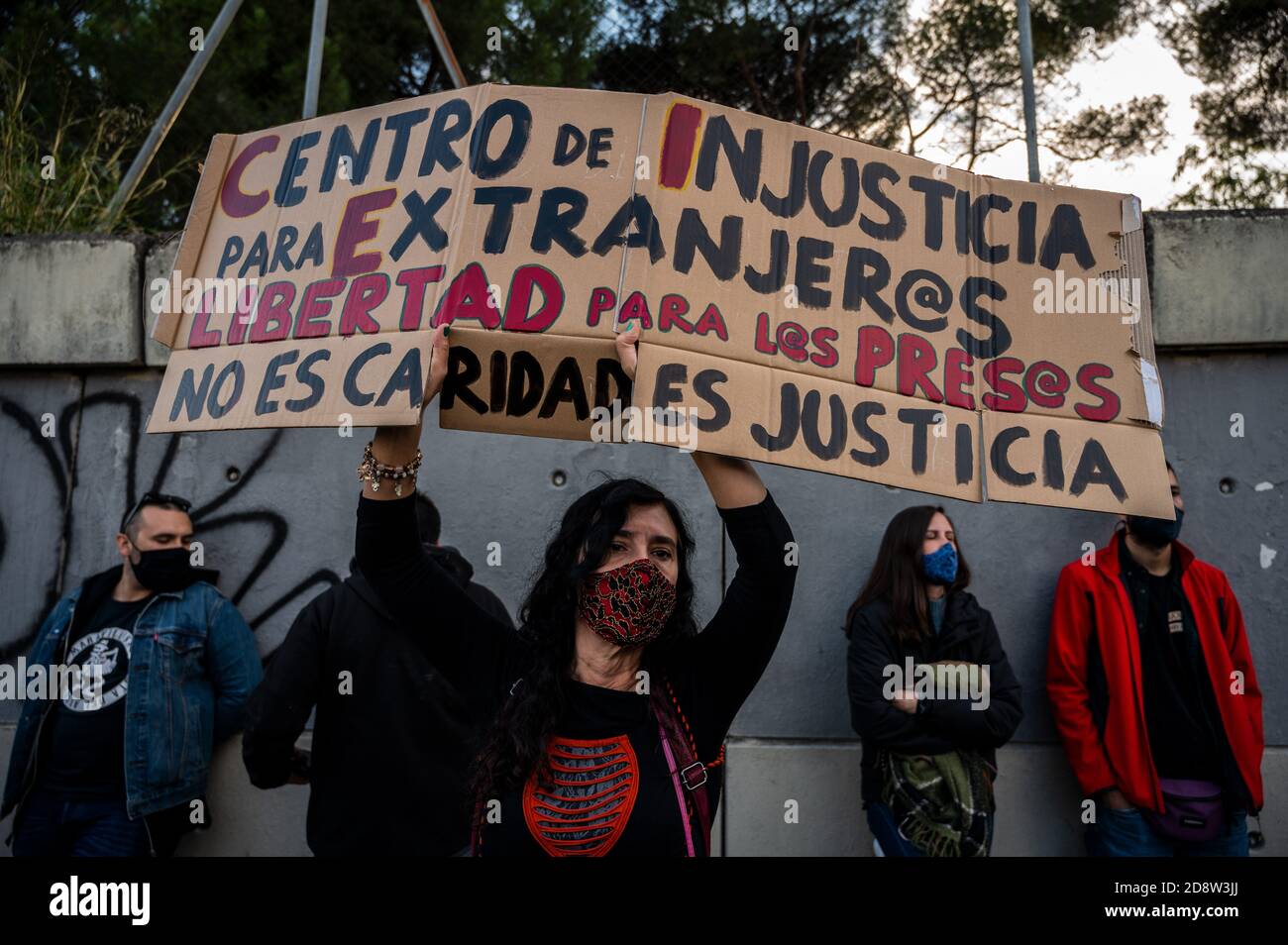 Madrid, Spagna. 01 Nov 2020. Un manifestante che tiene un cartello durante una manifestazione presso il Centro di detenzione per stranieri (CIE) di Aluche, sostenendo 41 detenuti che sono in sciopero della fame dall'inizio di questa settimana per chiedere il loro rilascio. Sul cartello si legge: "Centro di ingiustizia per gli stranieri, libertà per i prigionieri, non è carità, è giustizia". Credit: Marcos del Mazo/Alamy Live News Foto Stock