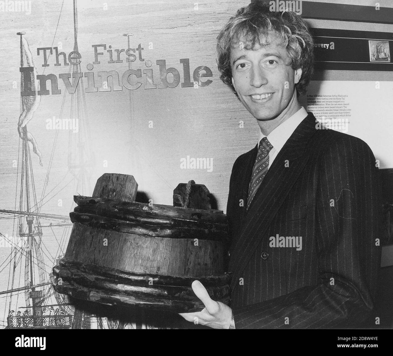 LA STAR POP ROBIN GIBB DEI GEES CON UN 'PIT KID' UNA DELLE RELIQUIE RECUPERATE DAL RELITTO DELL'UOMO O GUERRA INVINCIBILE CHE AFFONDÒ A PORTSMOUTH NEL 1758. PORTSMOUTH 1983 Foto Stock