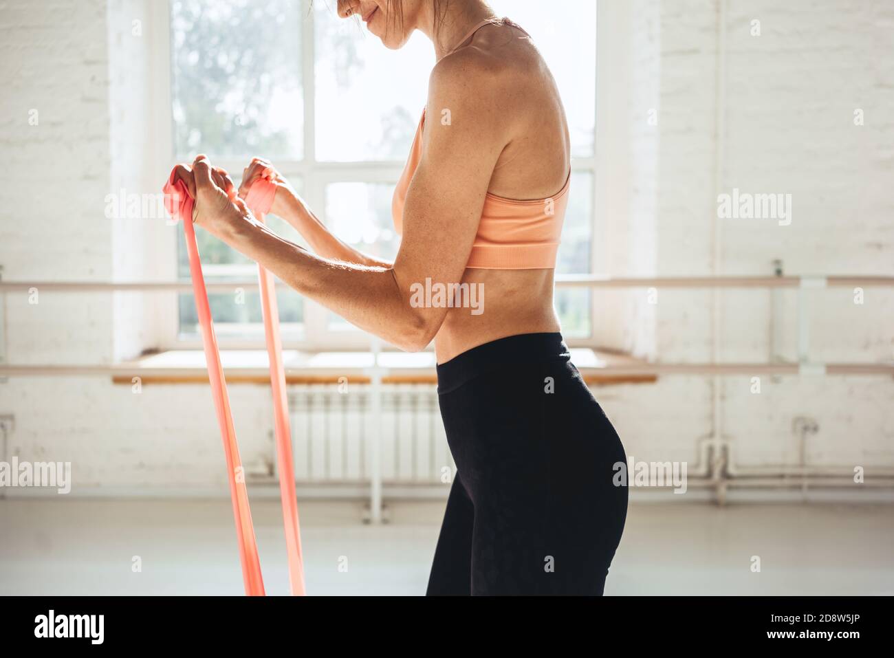 Fit donna che lavora con la fascia elastica. Sportivo che fa esercizi di stretching con elastico fitness Foto Stock