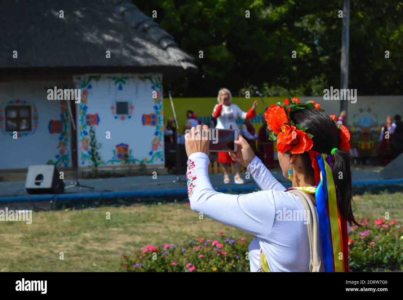 Velyki Sorochintsi, UCRAINA - 25 AGOSTO 2017: Donna vestita con abiti tradizionali scattando una foto sul telefono cellulare al mercato nazionale ucraino annuale Foto Stock