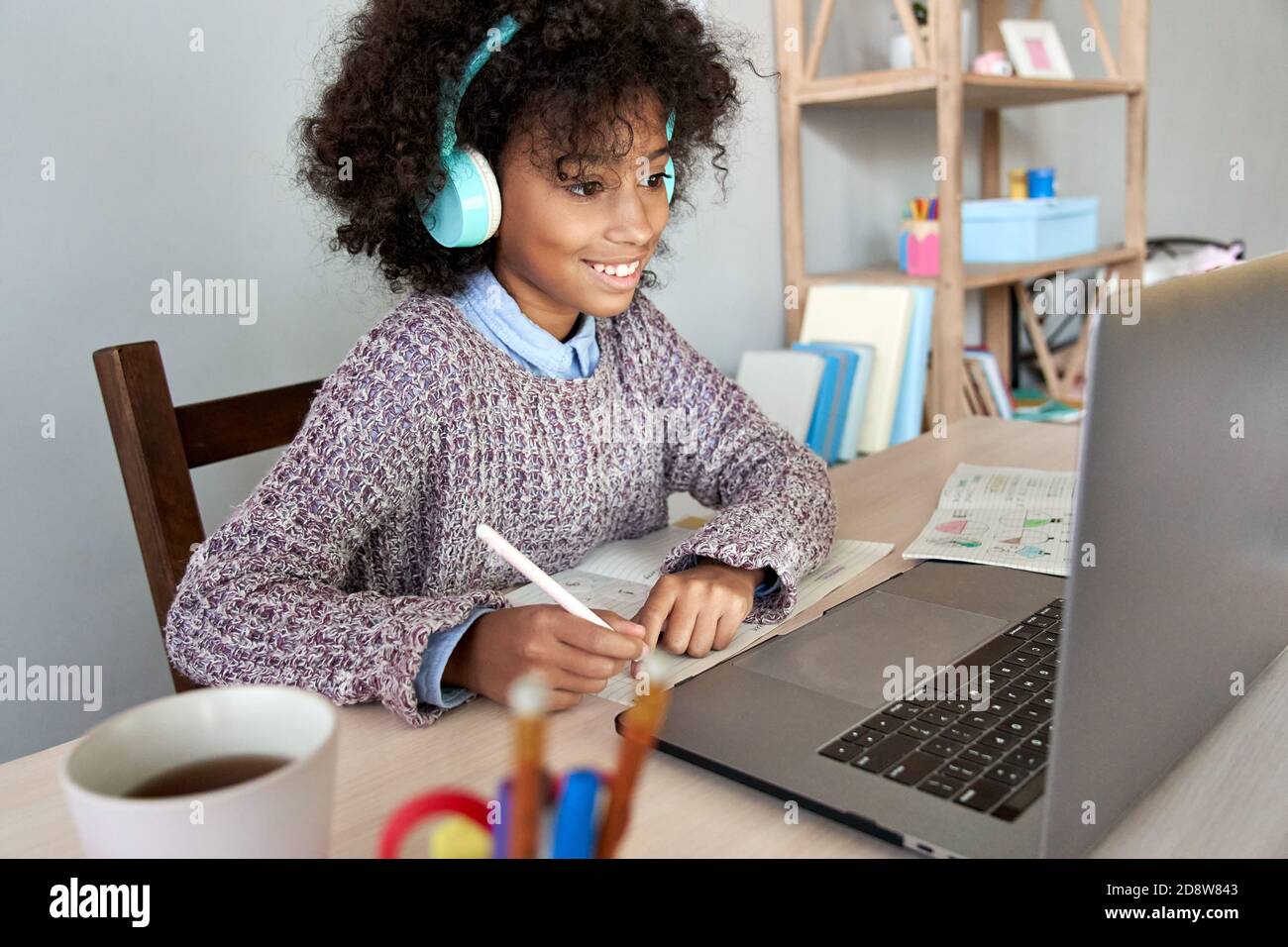 African School bambina che indossa le cuffie online apprendimento virtuale a casa. Foto Stock