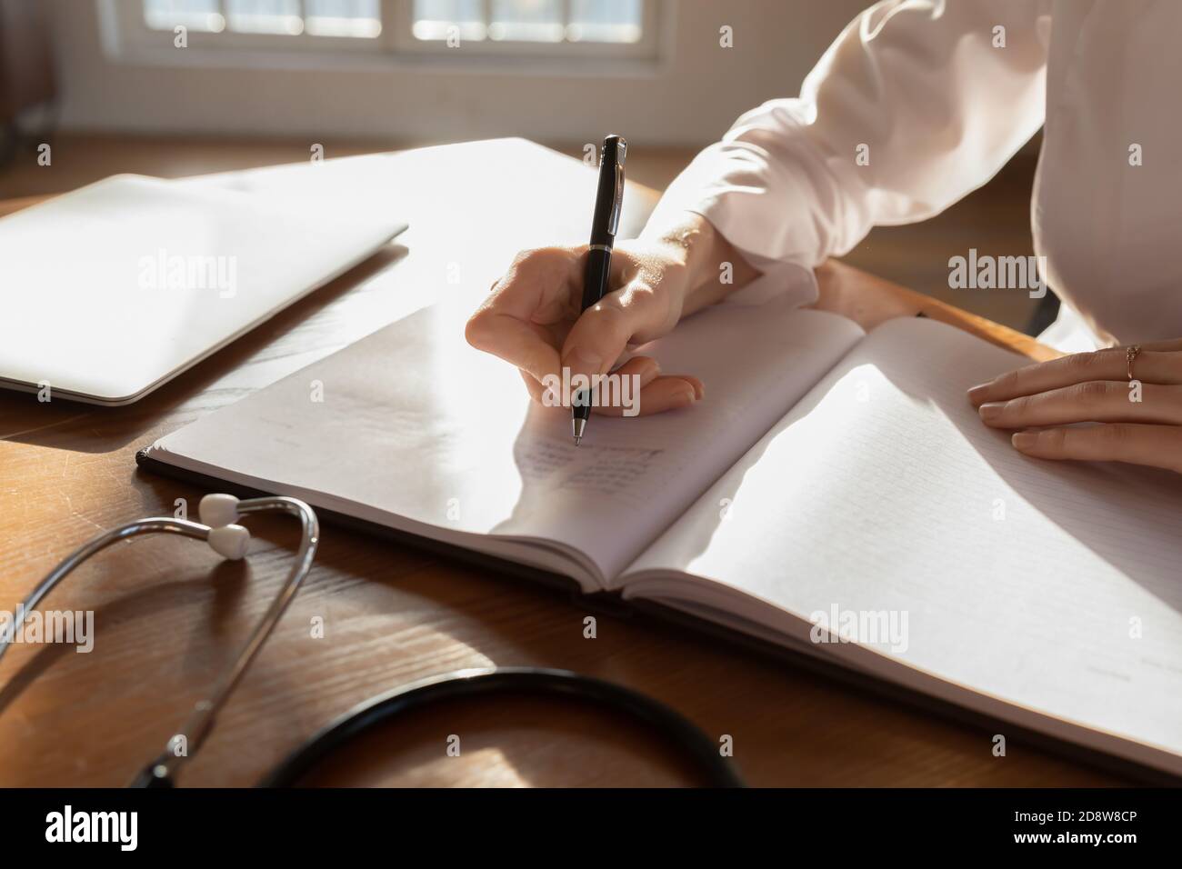 Closeup di occupato medico di scrivere note per registrare il libro Foto Stock