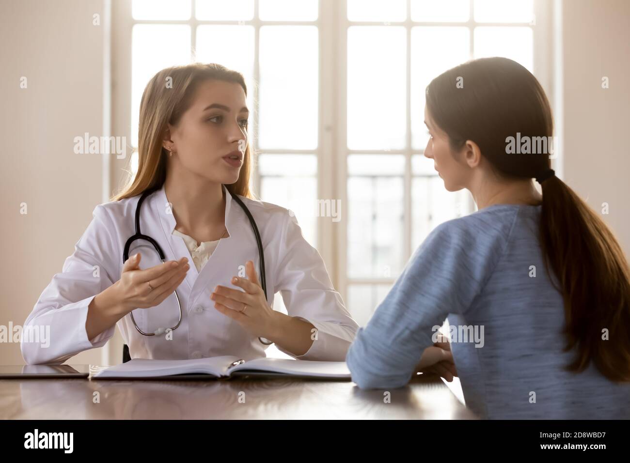 Tactful sicuro millennial donna medico che riceve consultando giovane donna paziente Foto Stock