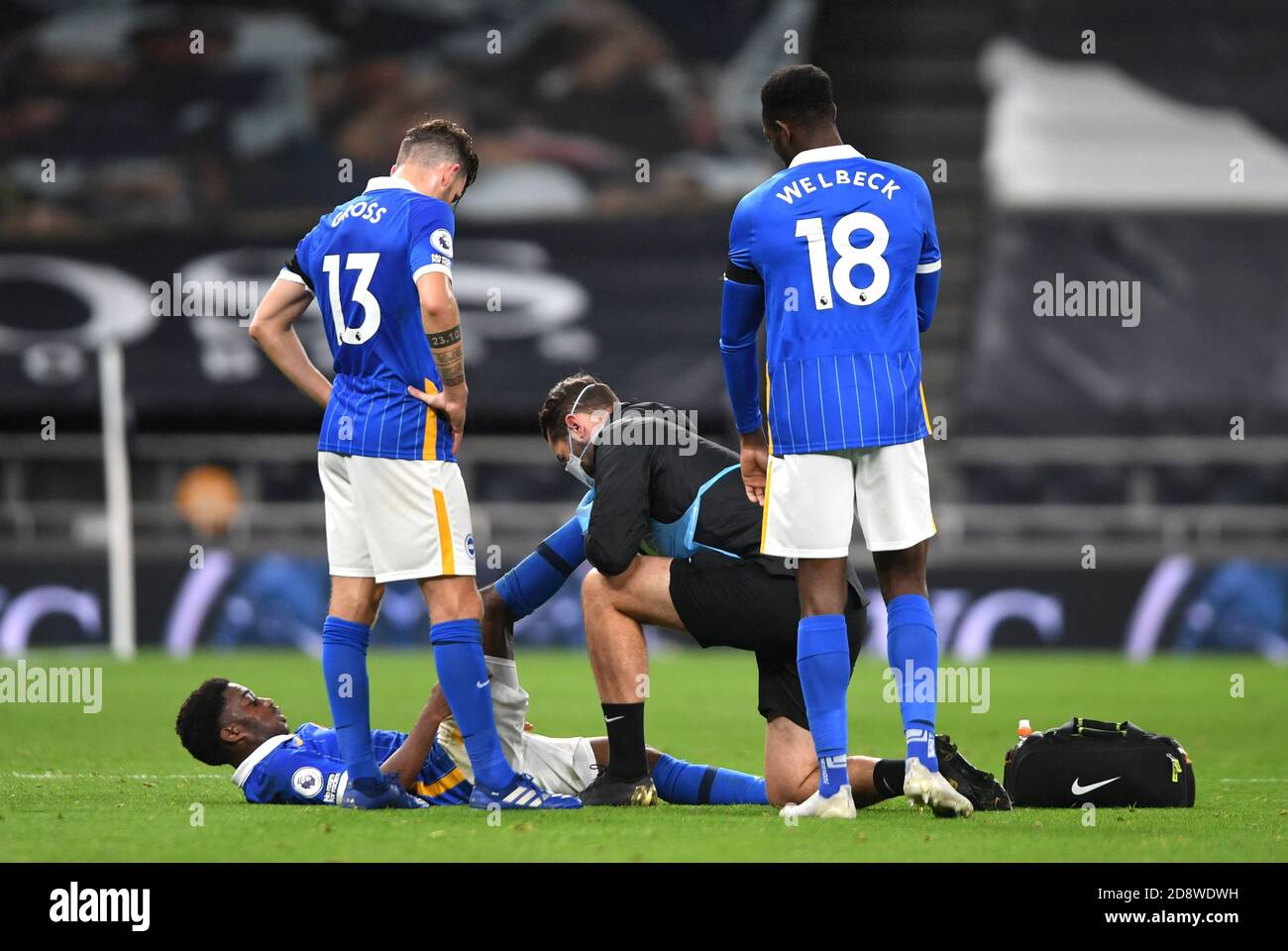 Il Tariq Lamptey di Brighton e Hove Albion (piano) riceve un trattamento per un infortunio durante la partita della Premier League al Tottenham Hotspur Stadium di Londra. Foto Stock