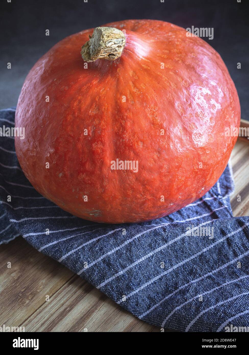 Zucca su sfondo di legno e tovagliolo blu Foto Stock