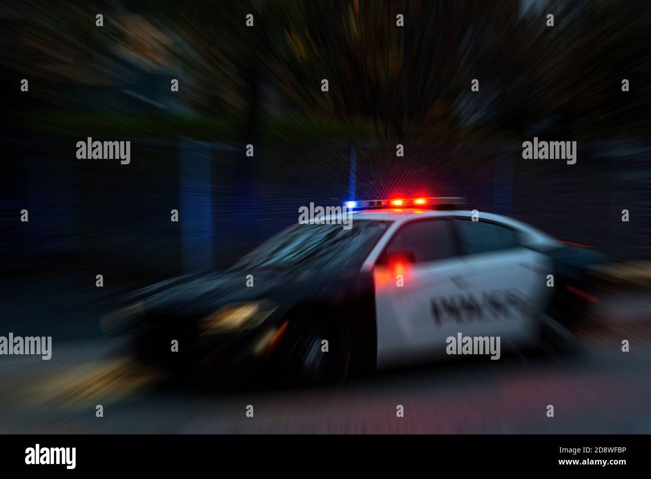 sfocatura radiale di una macchina della polizia di notte. Le luci rosse e blu sulla parte superiore sono accese. Auto rendere non identificabile. La sfocatura irradia dalle luci. Foto Stock