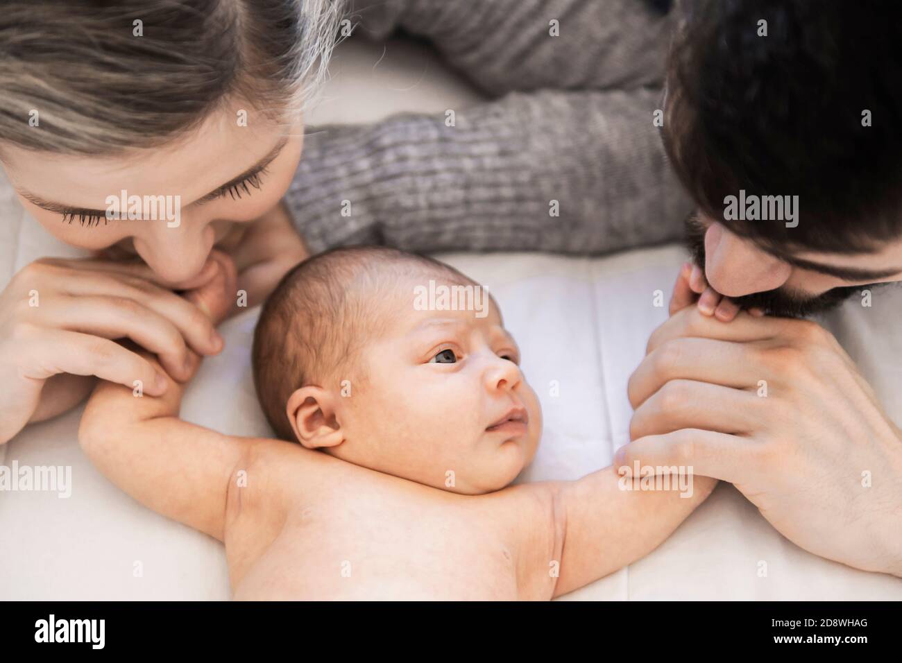 la famiglia si stese a letto con la sua figlia neonato Foto Stock