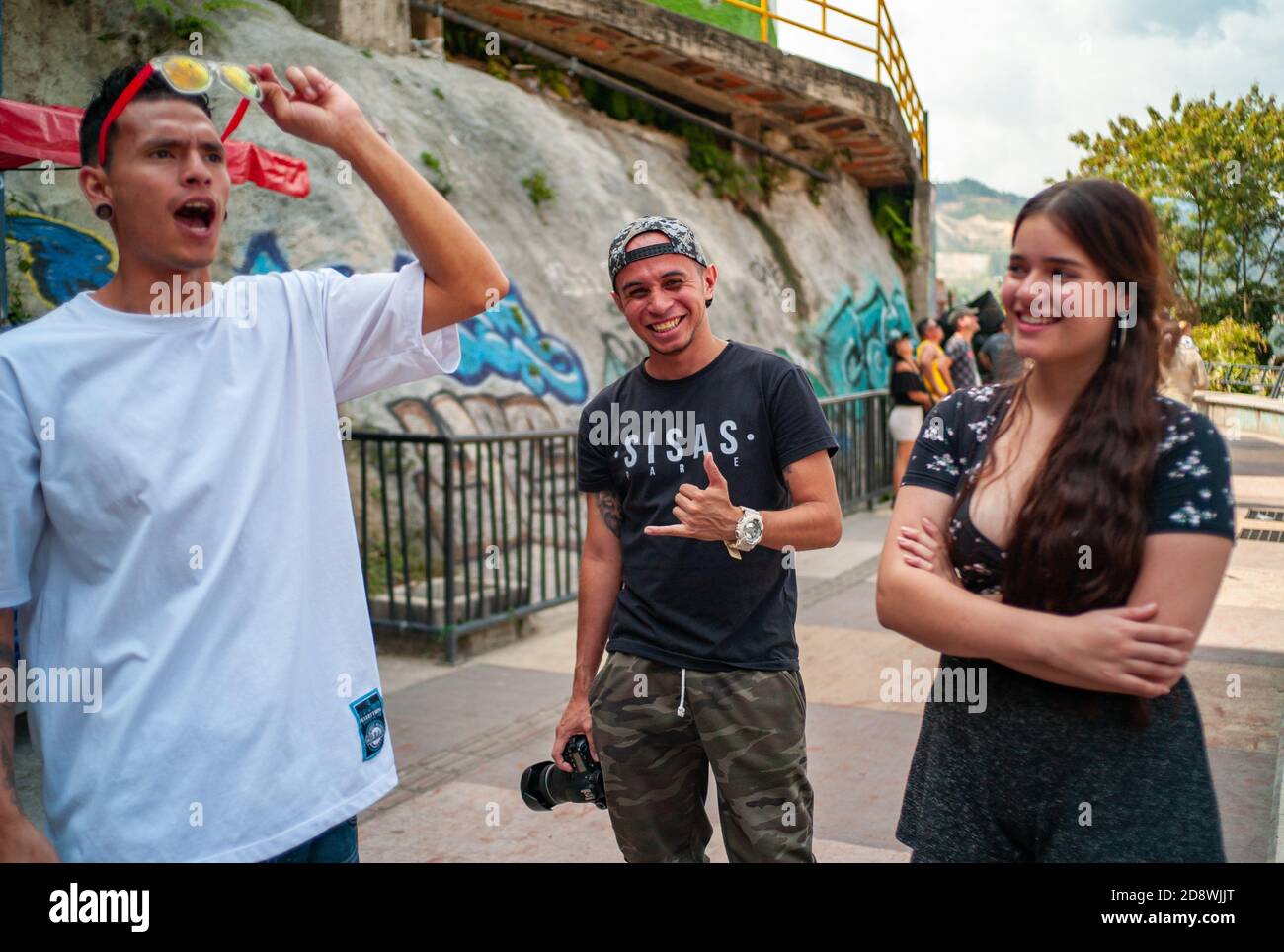 MEDELLIN, COLOMBIA - 03 febbraio 2019: Medellin, Antioquia, Colombia - 2 febbraio 2019: Ragazza con un lungo capelli accanto a due uomini con una fotocamera fotografica Foto Stock