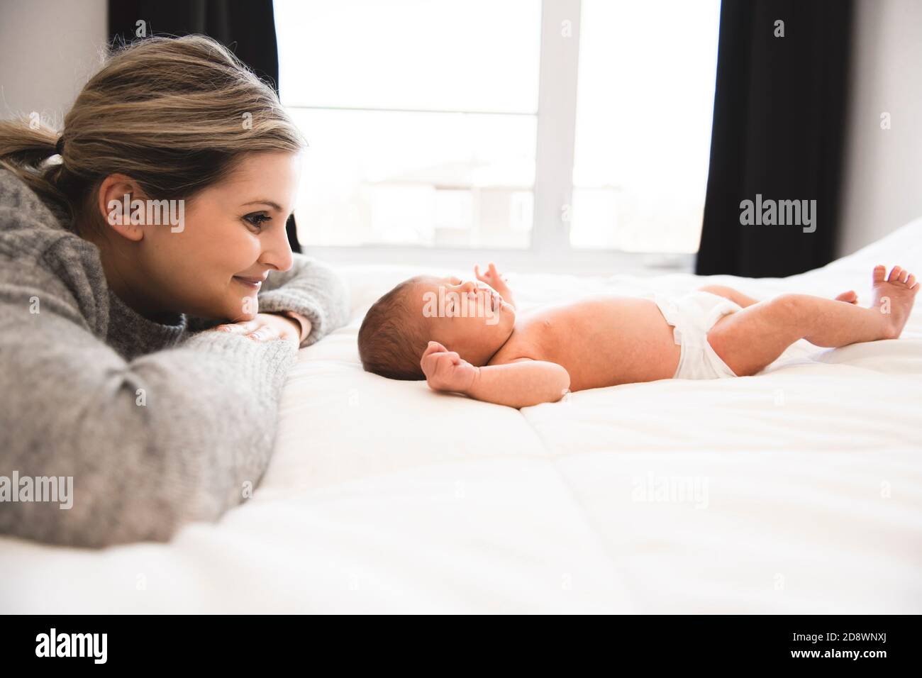 La madre si stese a letto con la figlia del neonato Foto Stock