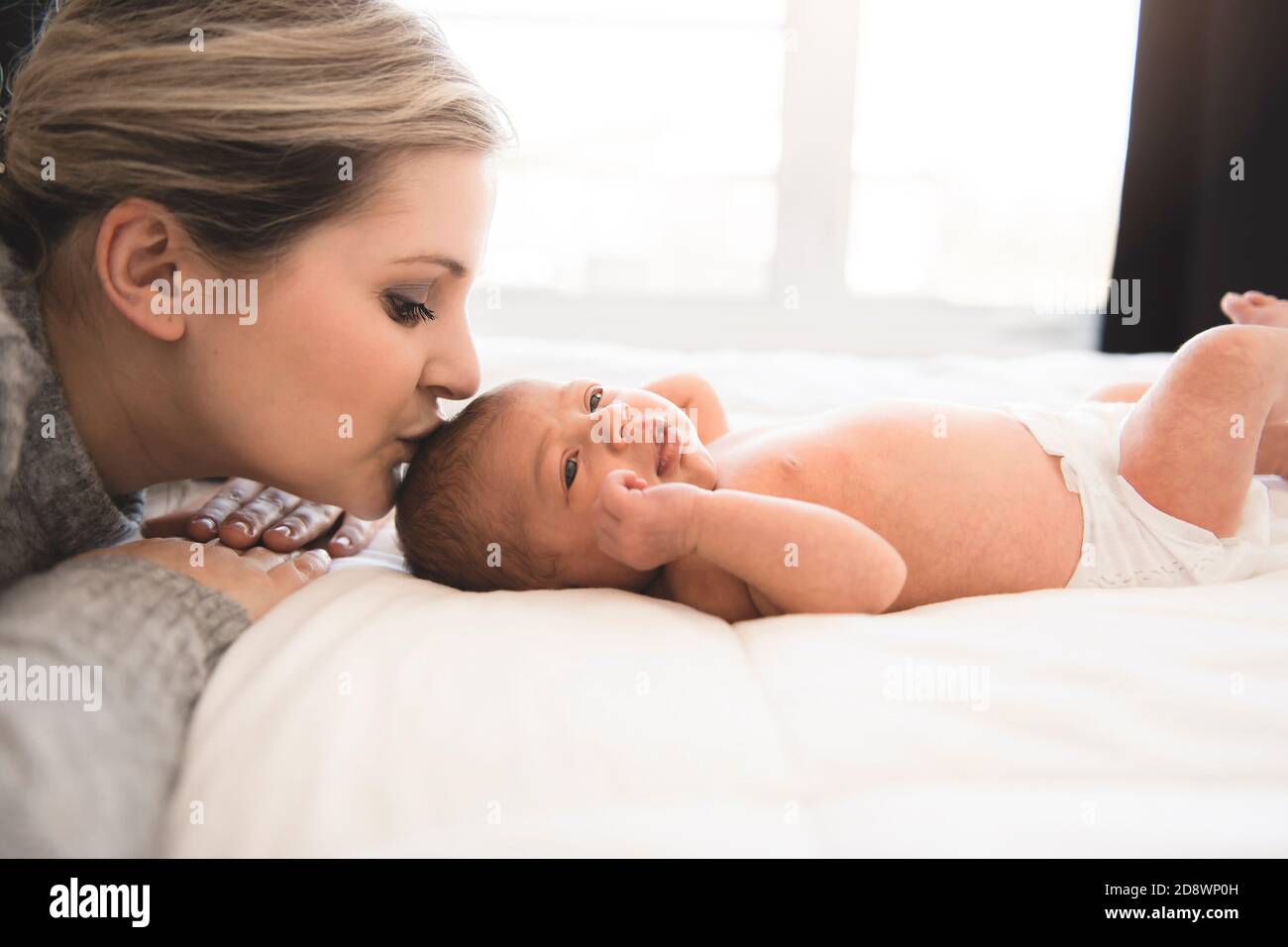 La madre si stese a letto con la figlia del neonato Foto Stock