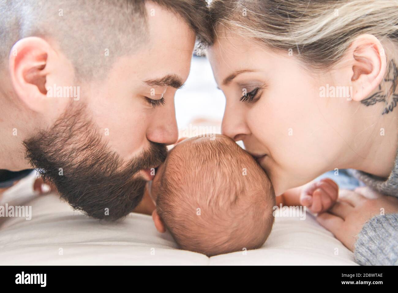 la famiglia si stese a letto con la sua figlia neonato Foto Stock