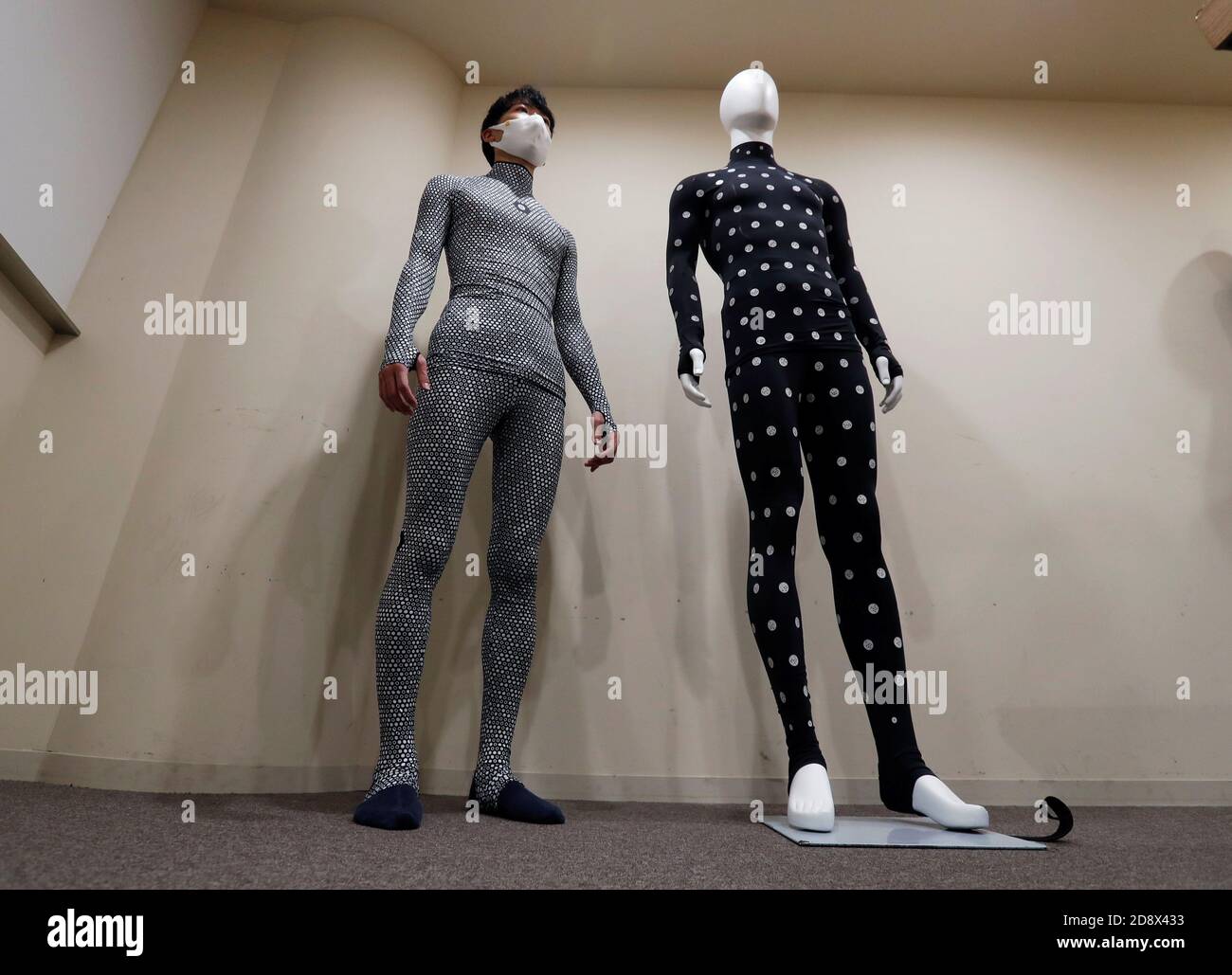 Un dipendente del rivenditore di moda online Zozo Inc. Dimostra la  Zozossuit 2 dell'azienda, una tuta per la misurazione del corpo 3D, presso  l'ufficio di Tokyo, Giappone, il 30 ottobre 2020. Foto