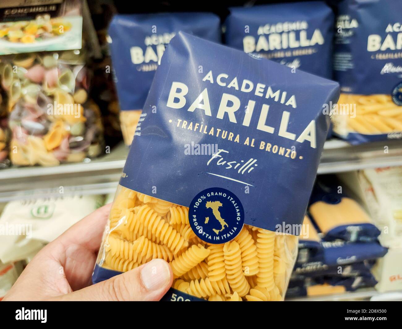 Puilboreau, Francia - 14 ottobre 2020: Primo piano di Man Hand acquisto di un pacchetto di fusilli pasta Barilla marca display per la vendita nel supermercato francese Foto Stock