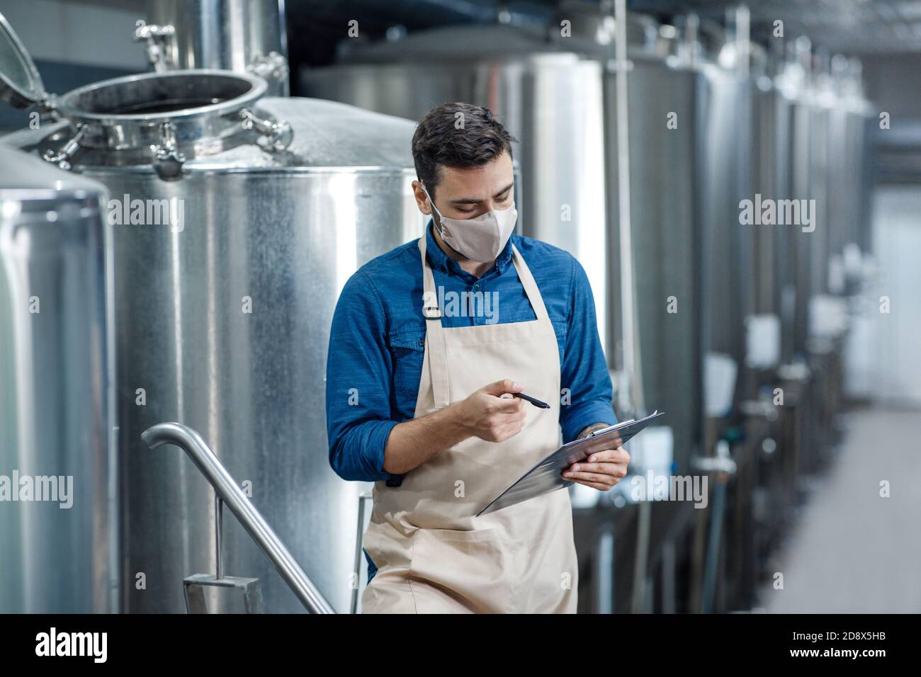 Il tecnico ispeziona lo stabilimento, il tecnico che lavora alla manutenzione e registra i dati sull'elenco di controllo Foto Stock