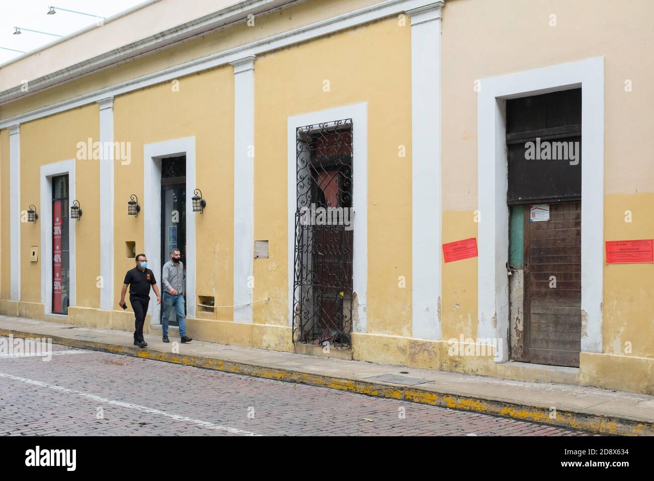 Persone che camminano in un centro di Merida quasi vuoto durante il Covid19 Pandemic, novembre 2020 - molti negozi sono stati chiusi e molte imprese sono andati fuori di affari a causa delle restrizioni Coronavirus. Merida, Yucatan, Messico Foto Stock