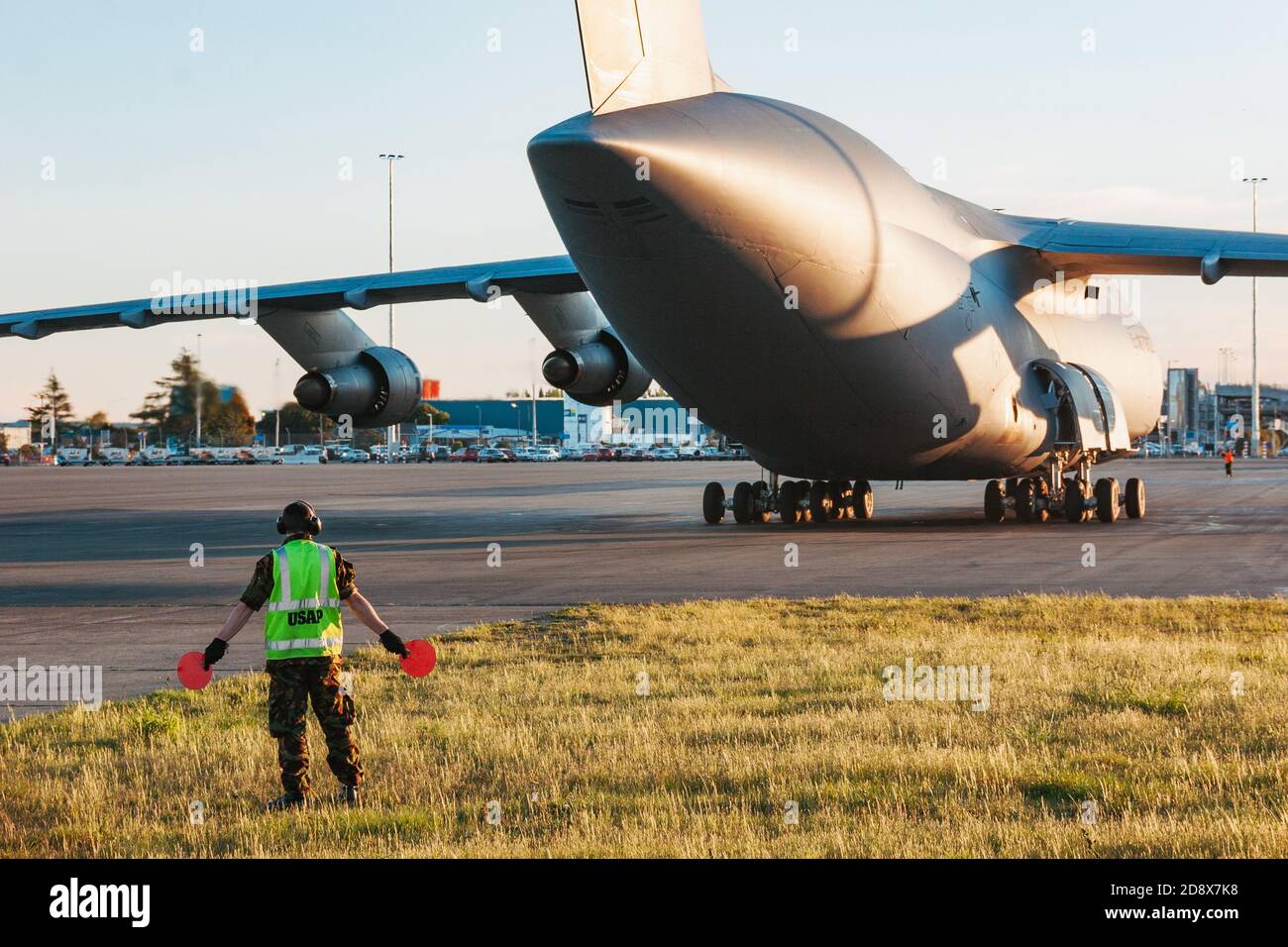 Un marshaller del programma antartico degli Stati Uniti si trova dietro un aereo da carico militare C-5 Galaxy durante le manovre all'aeroporto di Christchurch, Nuova Zelanda Foto Stock