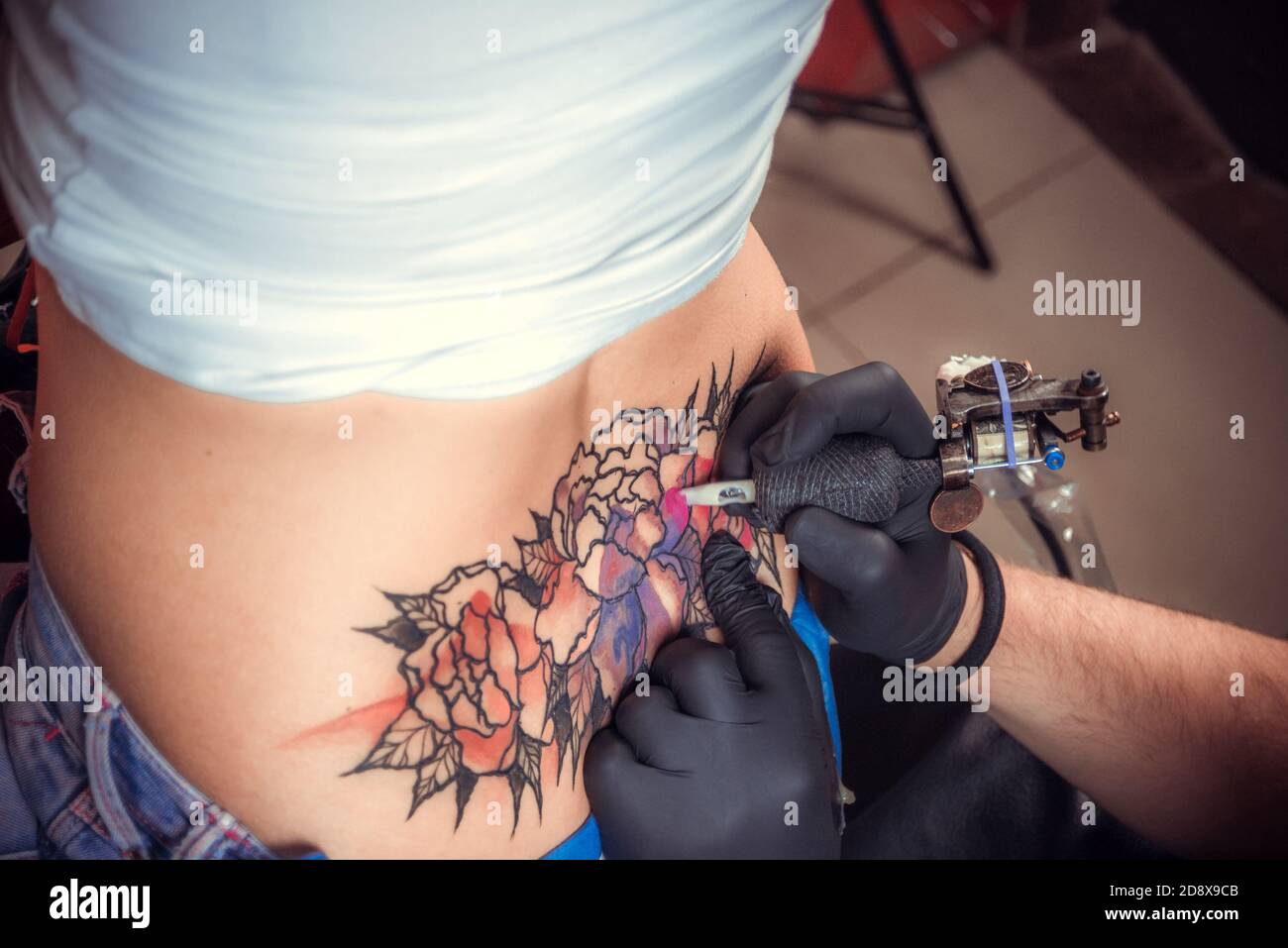 Tattooer durante una sessione di tatuaggio Foto Stock