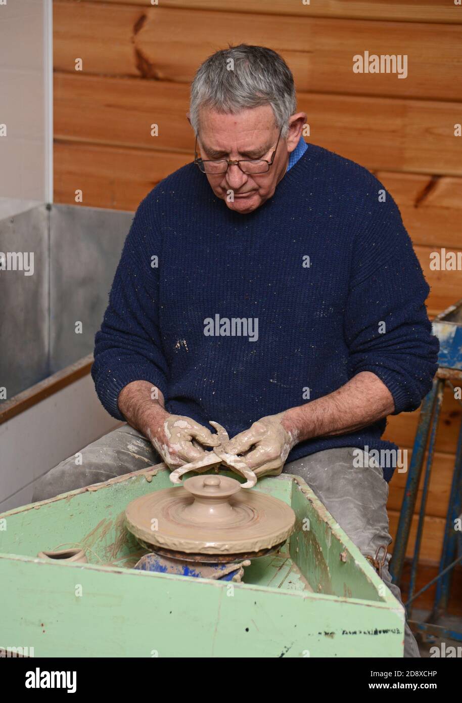 GREYMOUTH, NUOVA ZELANDA, 11 AGOSTO 2020: Un vasaio usa un paio di calibri per controllare il diametro del coperchio che ha gettato su una ruota di ceramica. Foto Stock