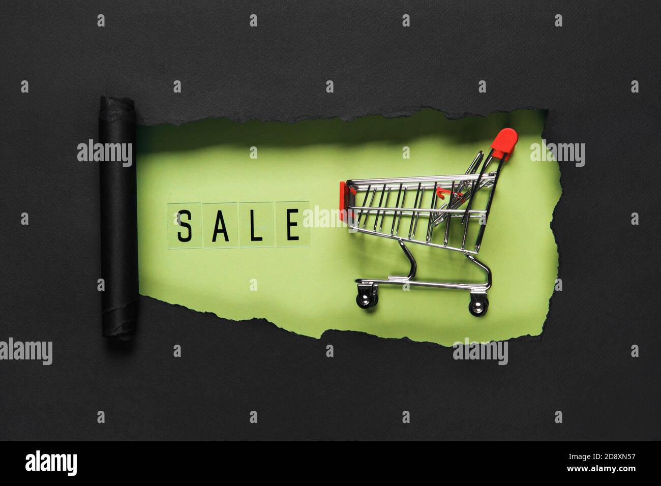 Testo DI VENDITA su sfondo foro verde con carrello. Promozione Sconto per lo shopping Foto Stock